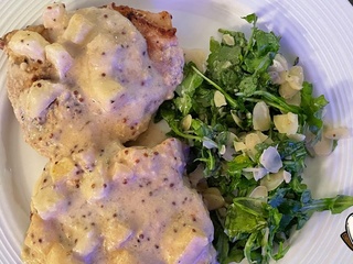 Côtelettes de porc, sauce pomme et moutarde et salade de roquette