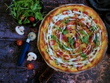 Pizza blanche aux tomates cerises, jambon de parme, champignons et roquette