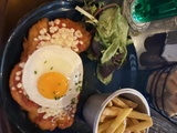 Escalopes de poulet pané, sauce tomate, œuf à cheval, mesclun et frites