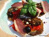 Tartines grillées, garnies de filets d'aubergine et de poivrons grillés à l'huile d'olive avec du magret de canard